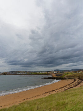 Ruby Beach near to the Coastal Villages of Earlsferry and Elie in the distance, with dark clouds above  threatening rain.