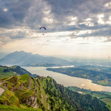 Paraglider soaring above Mount Rigi with view of Lake Lucerne and city