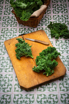 Fresh kale lies on a rustic wooden cutting board