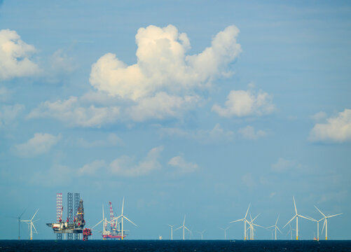 The North Sea surrounds a drilling platform and a windfarm