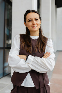 Smiling businesswoman shows confidence outside the office building