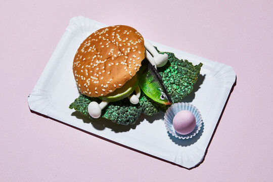 Hamburger with toy fish on paper plate