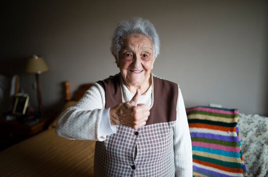 Senior woman giving thumbs up, smiling