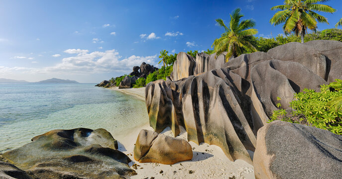 Seychelles, La Digue, view to Anse Source d' Argent with sculpted rocks and palm trees