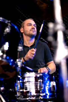 A man plays the drums during rehearsal in a music studio
