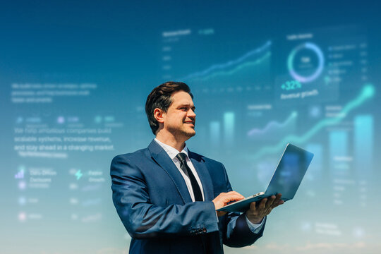Businessman uses laptop outdoors with data graphics