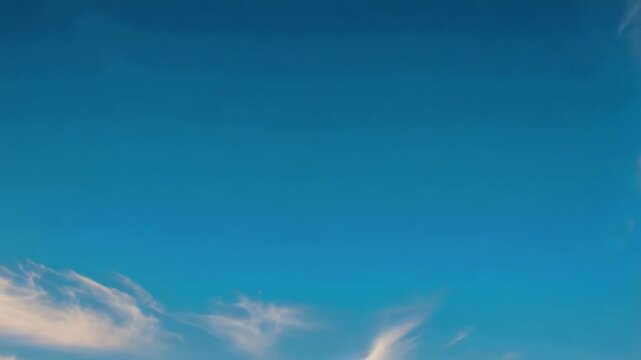 Wispy cirrus clouds drifting and changing across a bright blue sky, creating a tranquil atmospheric time lapse with expansive natural sky scenery