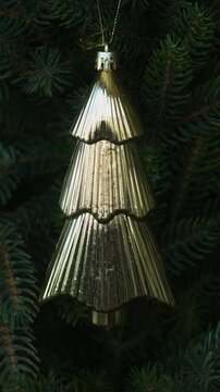 Vertical video. Woman decorating Christmas tree with Christmas bauble.