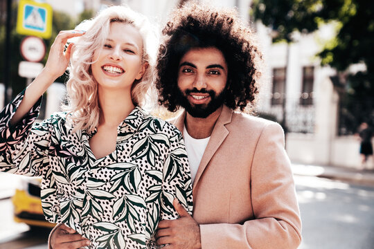 Beautiful fashion woman and her handsome elegant boyfriend in beige suit. Sexy blond model in summer suit clothes. Fashionable smiling couple posing in street Europe. Brutal man and female outdoors