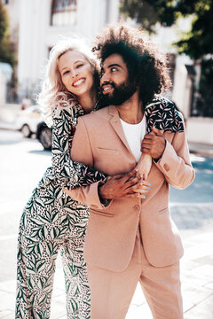 Beautiful fashion woman and her handsome elegant boyfriend in beige suit. Sexy blond model in summer suit clothes. Fashionable smiling couple posing in street Europe. Brutal man and female outdoors