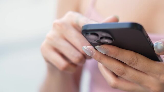 woman holds smart phone in her hands and scrolls through the news feed. Close up of hand uses mobile. point finger on screen, texting text message.