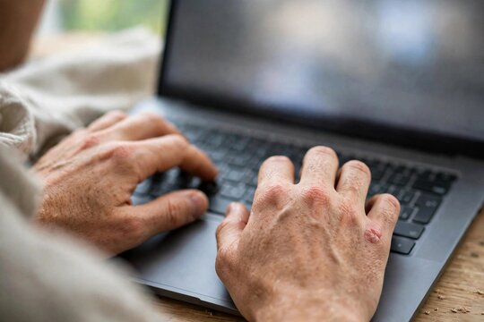 Close up of hands typing on a laptop keyboard