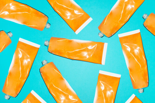 Directly above view of orange paint tubes on blue background