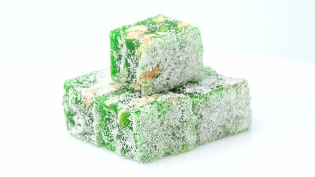 Assorted colorful Turkish delight sweets with nuts and coconut flakes rotating slowly close up. Rahat Lokum	
