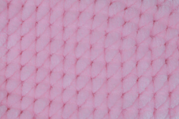 Full frame texture of soft pink knitted plush fabric with geometric diamond mesh pattern ideal for baby blanket, textile mockup, or backdrop © moryachka