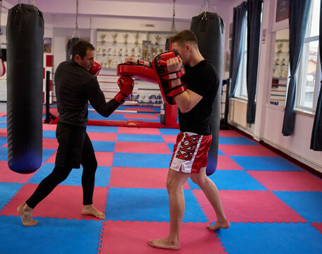 Coach throwing uppercut into pads