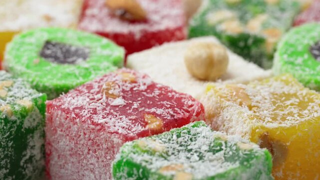 Assorted colorful Turkish delight sweets with nuts and coconut flakes rotating slowly close up. Rahat Lokum	
