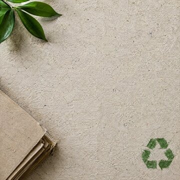 Recycled paper sheets with a green recycling symbol