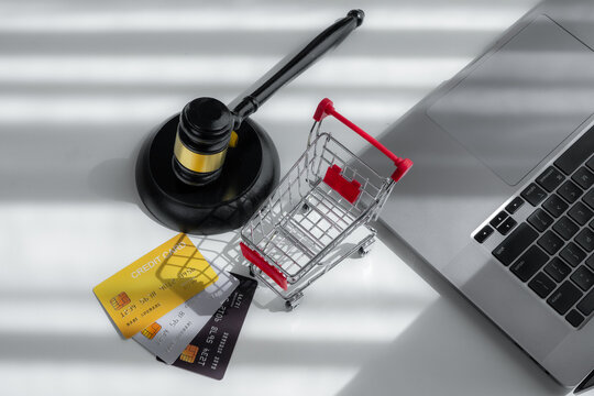 Judge gavel, shopping cart, credit cards and laptop represent ecommerce law, consumer protection, online payment disputes, retail regulation, fraud prevention and digital commerce.