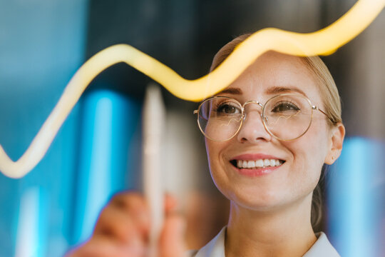 Businesswoman analyzes digital data chart on transparent screen