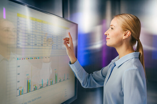 Businesswoman analyzes financial data on a modern interactive screen