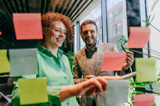 Smiling businessman and businesswoman brainstorm ideas in the office