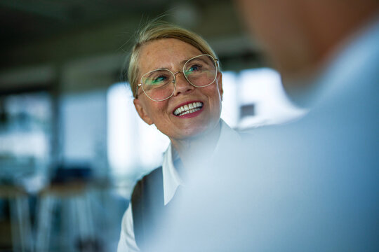 Smiling businesswoman discusses a contract with a colleague indoors