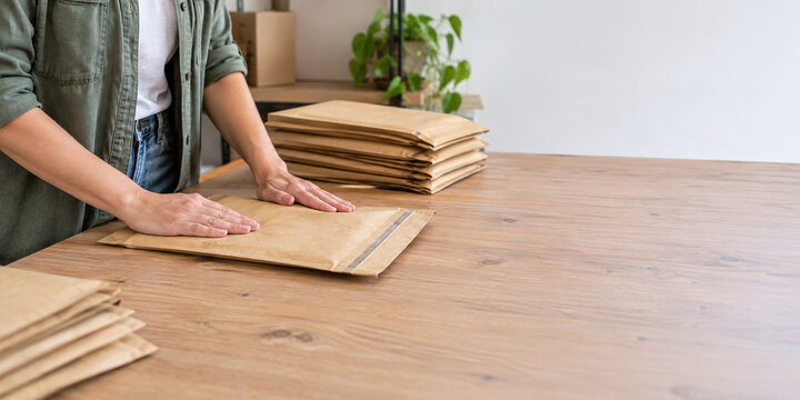 Worker flattening reusable mailers for another cycle