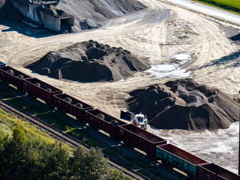 Aerial view of the Dolomitas industrial quarry site with freight train cars being loaded with gravel and stone piles in Petrasiunai, Siauliu apskritis, Lithuania.