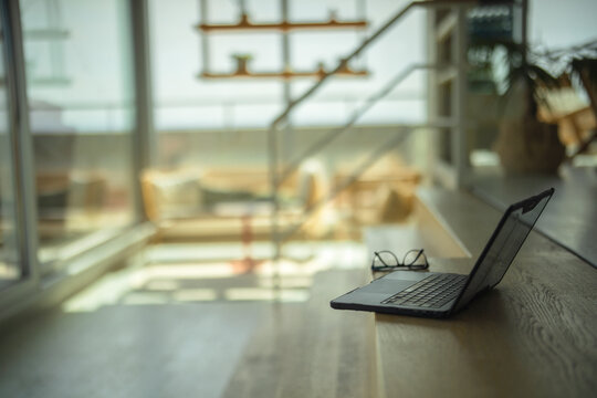 Laptop and eyewear on wooden staircase in modern office in Germany