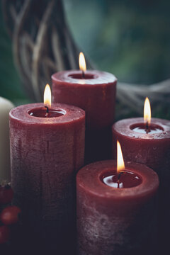 Burning red wax candles as a symbol of faith. Vertical background for religious traditions and holidays. Close-up with space for text. 