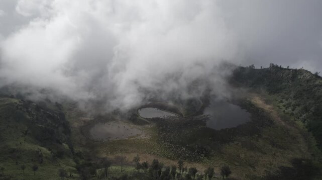 Aerial View of Fog and Mist Rolling Over Scenic Kawah Bulan Sabit Mountain Lakes in Volcanic Crater
