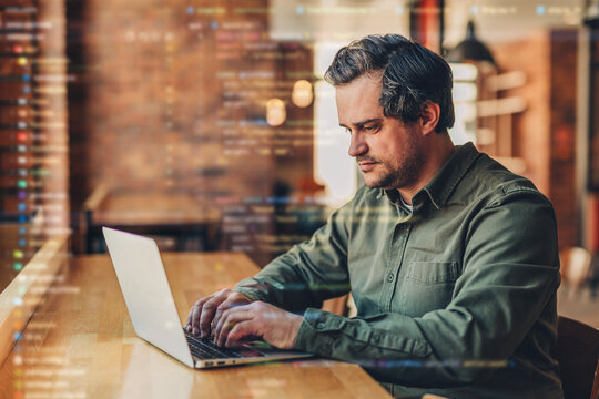 Businessman works on laptop in office cafe