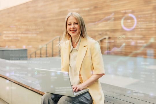 Smiling businesswoman works on a laptop in modern office