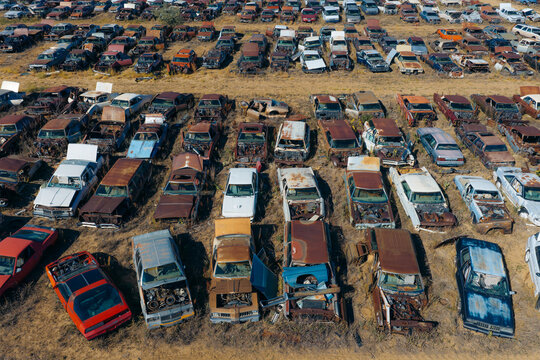 Aerial view of discarded and damaged vehicles arranged in massive rows at an automobile salvage and recycling facility in Dacono, Colorado, United States.