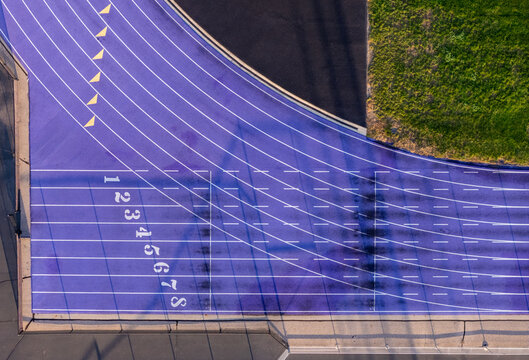 Aerial view of a purple running track with numbered lanes and surrounding green grass in Woodhaven, Michigan, United States.