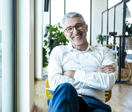 Smiling businessman relaxing at the modern office