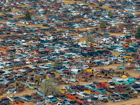Aerial view of an automobile salvage and recycling facility with thousands of discarded and damaged vehicles arranged in rows in Dacono, Colorado, United States.