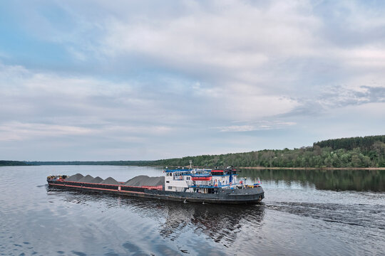 Push tug pushing heavy loaded barge on the Volga River, Russia