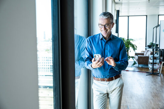 Businessman reads a message on his mobile device in the office
