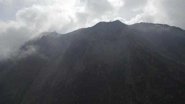 Moody Aerial View of Dramatic Mountain Peaks Enveloped in Thick White Clouds and Mist