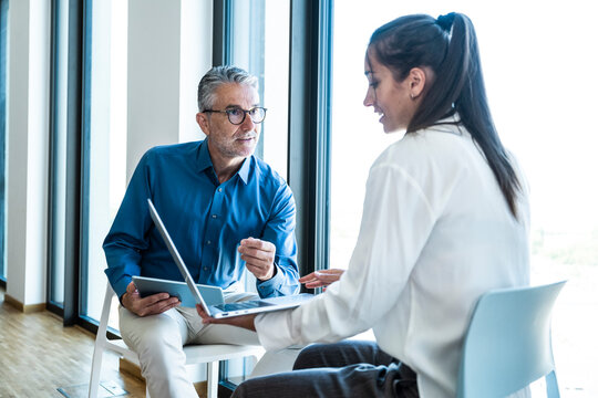 Mature businessman and young businesswoman having a meeting in office