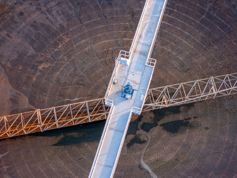Aerial view of clarifier tanks at a waste water treatment facility with metal walkways and industrial infrastructure in Monroe, Michigan, United States.