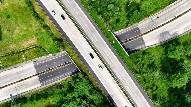 Aerial view of the Soreang highway interchange with vehicles driving on asphalt roads surrounded by lush green vegetation in Bandung, West Java, Indonesia.