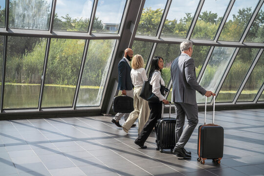 Businessmen and businesswomen walk in airport terminal