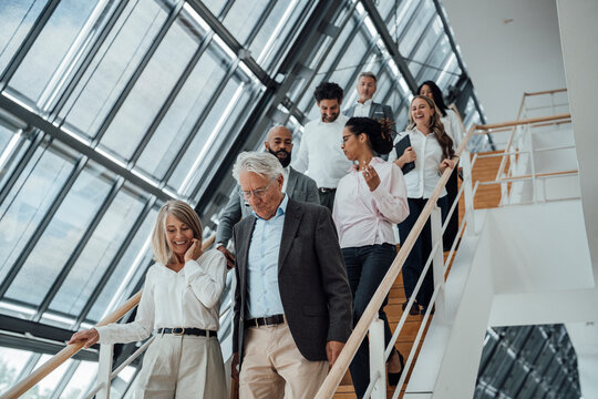 A business team descends a modern staircase at a trade fair