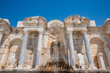 Water cascades through ancient fountain ruins with sculpted columns at Sagalassos in Turkey. Roman sculptures line the monumental fountain of Sagalassos in ancient Pisidia © Ensar