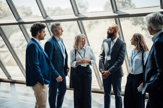 Businessmen and businesswomen talk at a conference