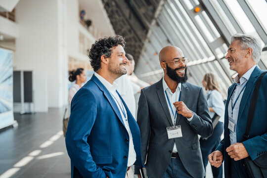 Smiling businessmen talk together at a trade fair