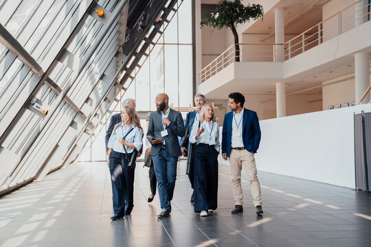 Businessmen and businesswomen walk in a convention center